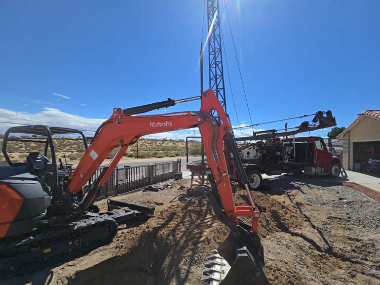 Kubota excavator and drilling truck on a septic installation job site in Victorville California